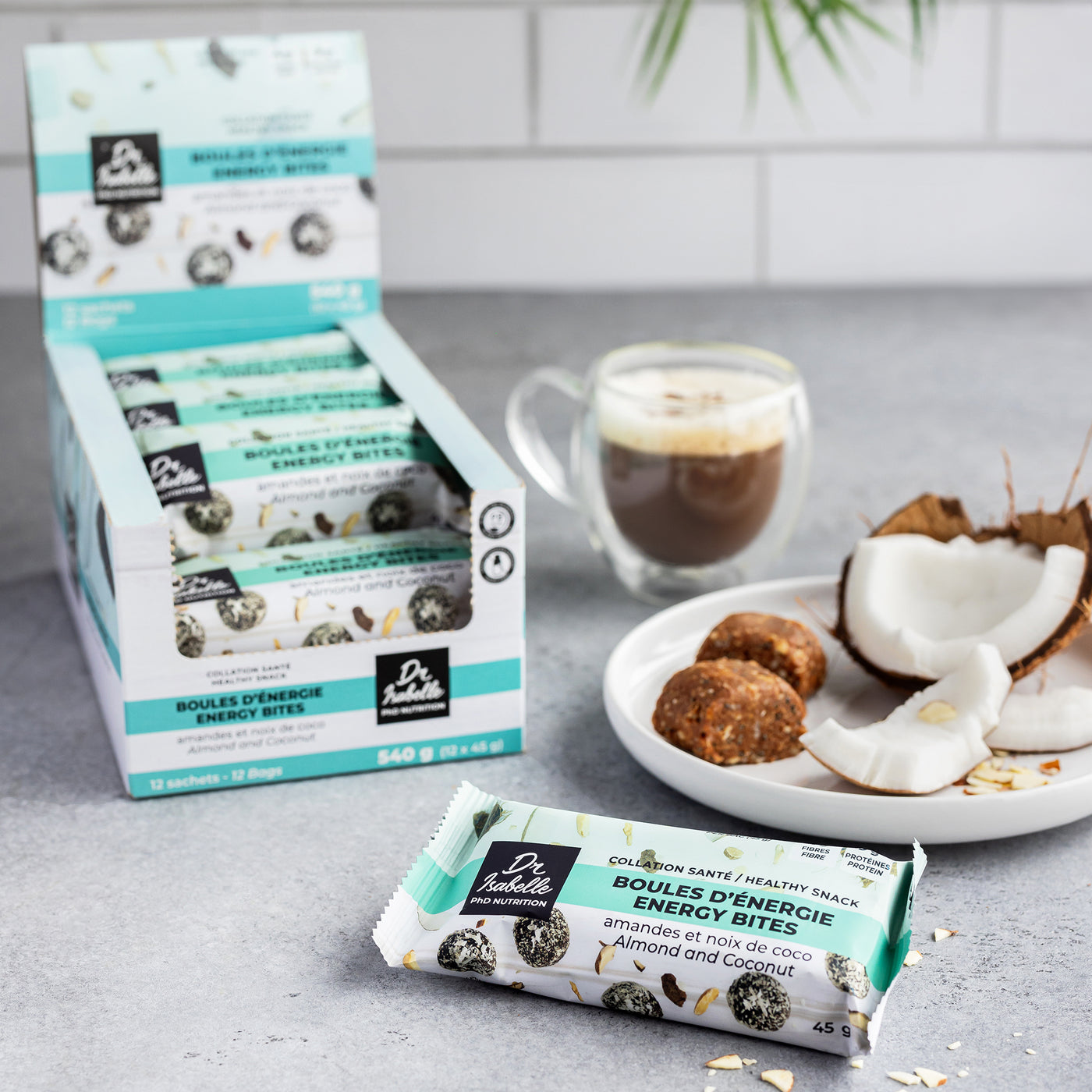 boite de 12 sacs de boules d'énergie amandes et coco. 8 g de protéines par portion, c'est la collation parfaite, santé et protéinée. // 12-bag box of almond and coconut energy balls. 8 g of protein per portion, the perfect healthy, high-protein snack.